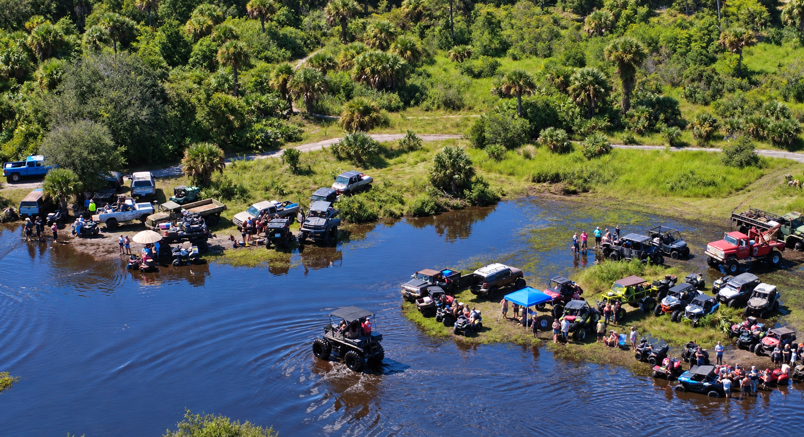 Off-road vehicles driving through a flooded trail area
